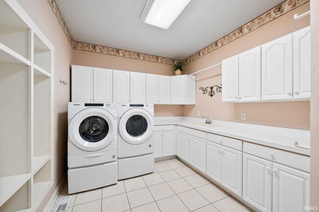 laundry area with washer and dryer, cabinets, light tile patterned floors, and sink