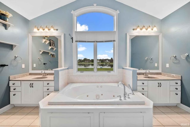 bathroom featuring vanity, vaulted ceiling, tile patterned floors, and a wealth of natural light