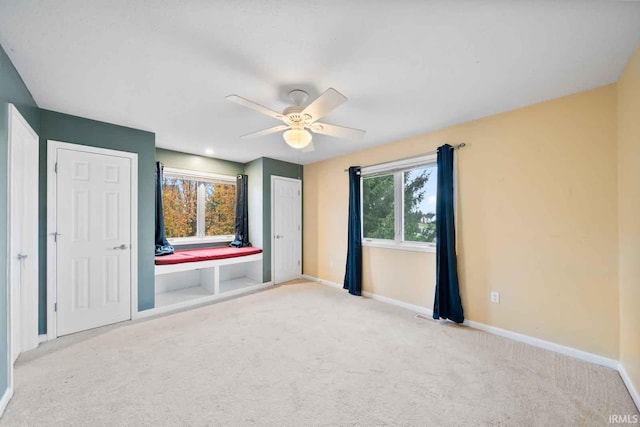 unfurnished bedroom with ceiling fan and light carpet