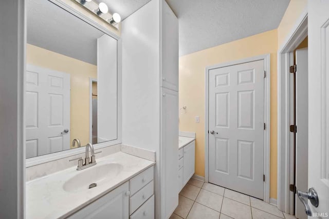 bathroom with vanity, a textured ceiling, and tile patterned flooring