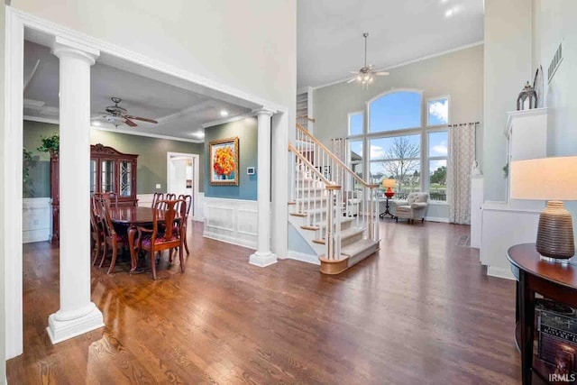 entryway with ceiling fan, ornate columns, dark wood-type flooring, and crown molding