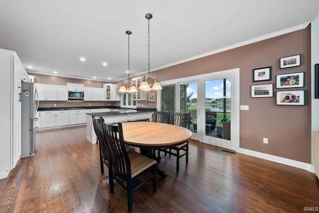 dining area with crown molding and dark wood-type flooring