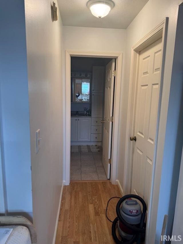 hallway with sink and wood-type flooring