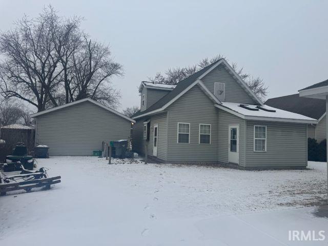 view of snow covered back of property