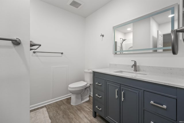 bathroom with vanity, hardwood / wood-style flooring, a shower, and toilet