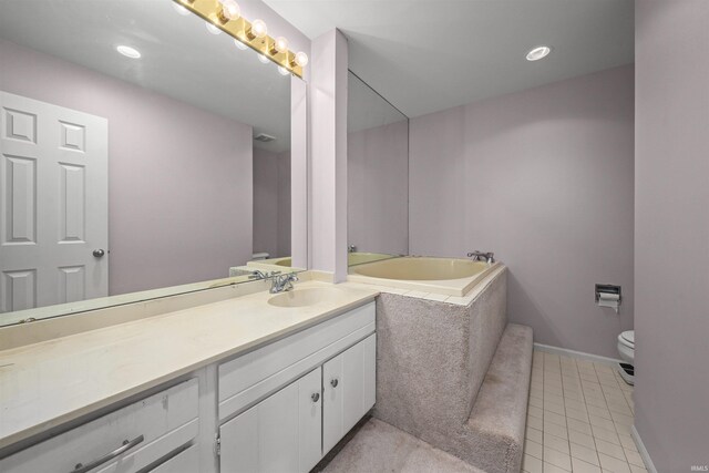 bathroom with a washtub, toilet, tile patterned floors, and vanity