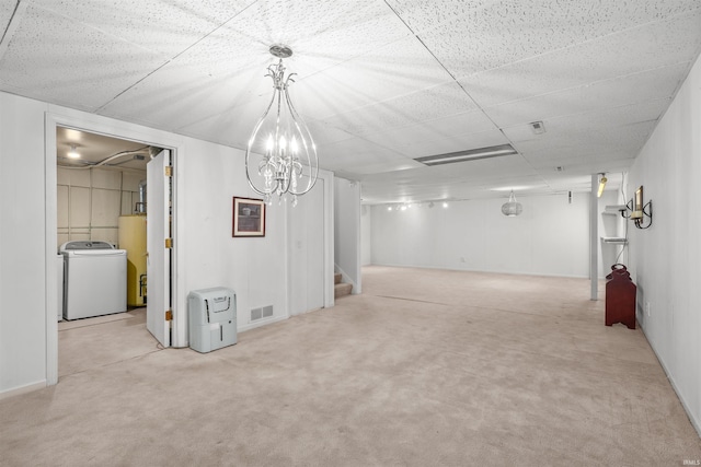 basement featuring light carpet, water heater, and washer / clothes dryer