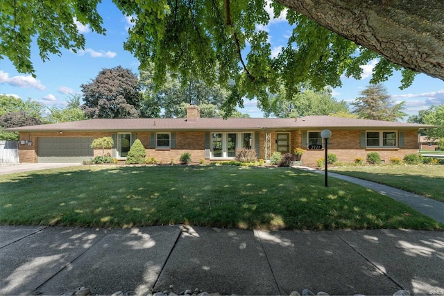 single story home featuring a garage and a front yard