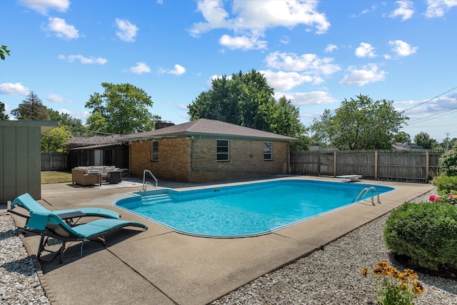 view of swimming pool with a diving board and a patio area