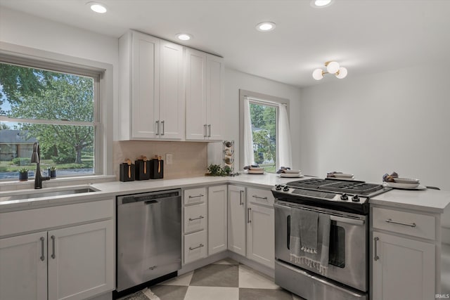 kitchen featuring sink, backsplash, white cabinets, and stainless steel appliances