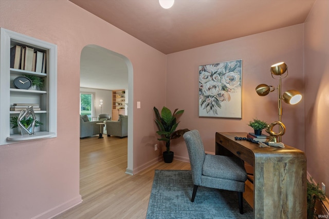 home office featuring built in features and light wood-type flooring