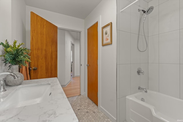 bathroom featuring vanity and tiled shower / bath