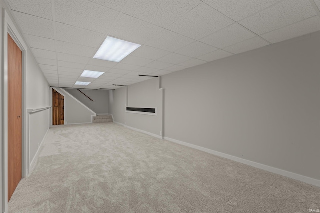 basement with light colored carpet and a drop ceiling