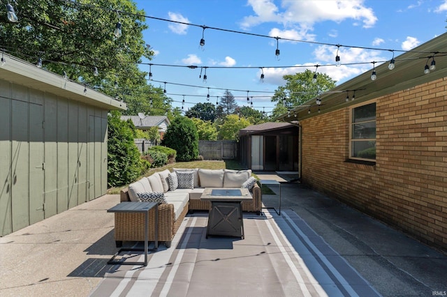 view of patio with an outdoor living space with a fire pit