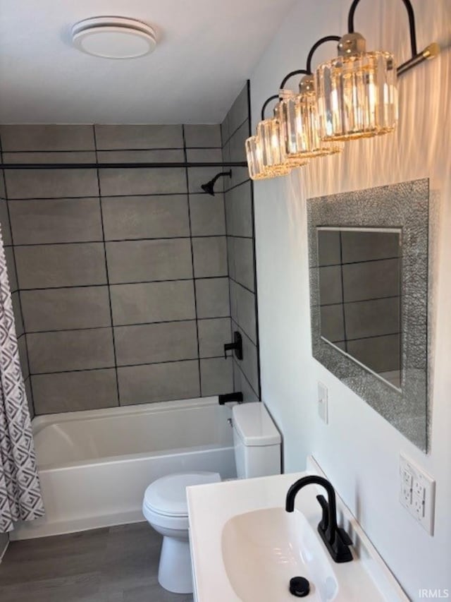 full bathroom with wood-type flooring, sink, toilet, a chandelier, and shower / bath combo