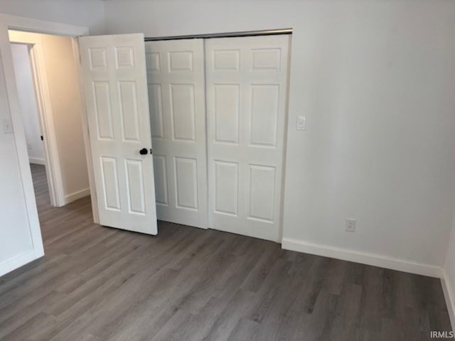 unfurnished bedroom featuring a closet and hardwood / wood-style flooring