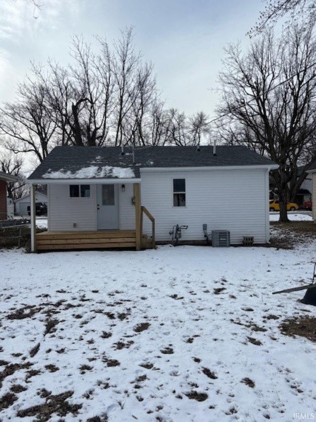 snow covered house with central AC unit