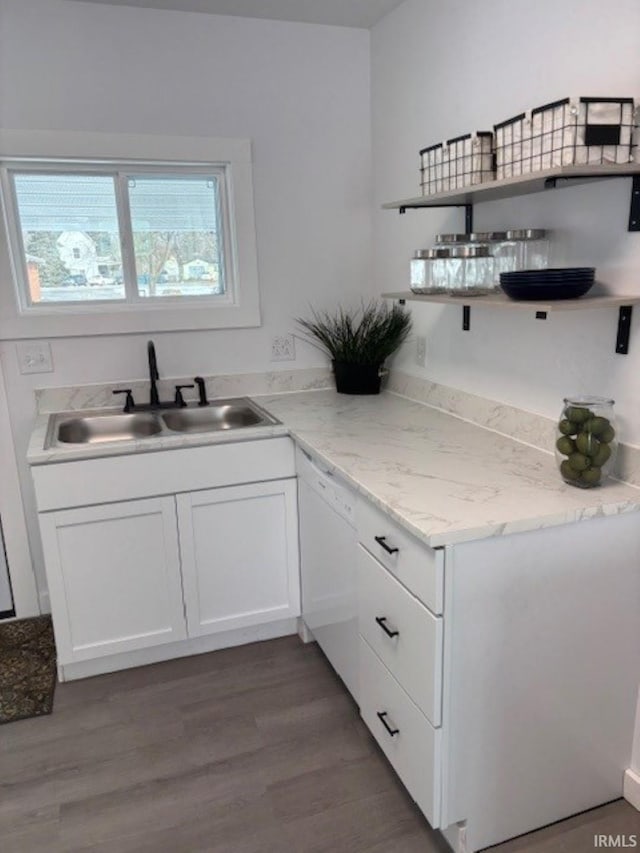 kitchen with sink, hardwood / wood-style floors, white cabinetry, and white dishwasher