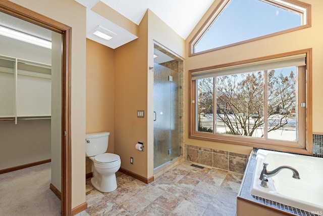 bathroom with vaulted ceiling, a bathing tub, and toilet