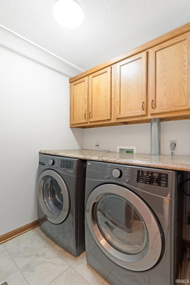 laundry room featuring cabinets and washing machine and clothes dryer