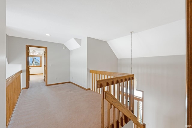 hallway with light colored carpet and vaulted ceiling