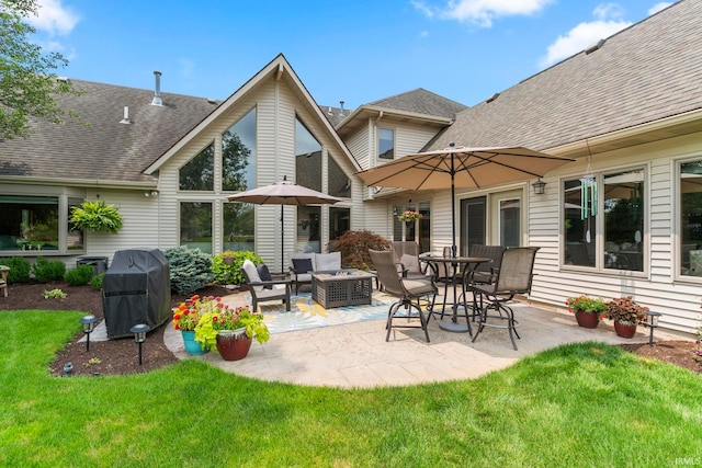 rear view of property featuring a lawn, a patio, and an outdoor living space with a fire pit