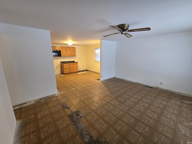 unfurnished living room with dark parquet floors and ceiling fan