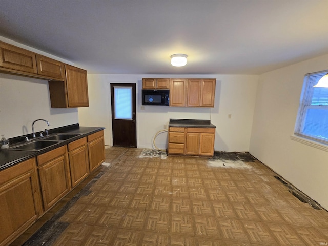 kitchen featuring sink, plenty of natural light, and parquet floors