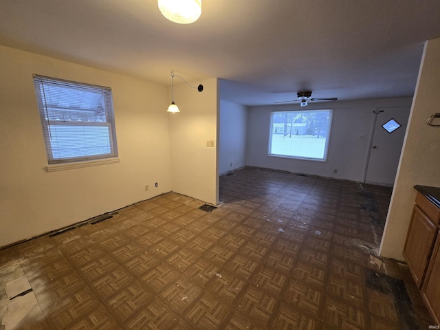 interior space with ceiling fan and dark parquet flooring