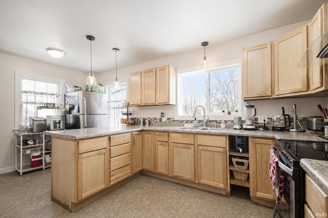 kitchen featuring light brown cabinetry, appliances with stainless steel finishes, hanging light fixtures, sink, and kitchen peninsula