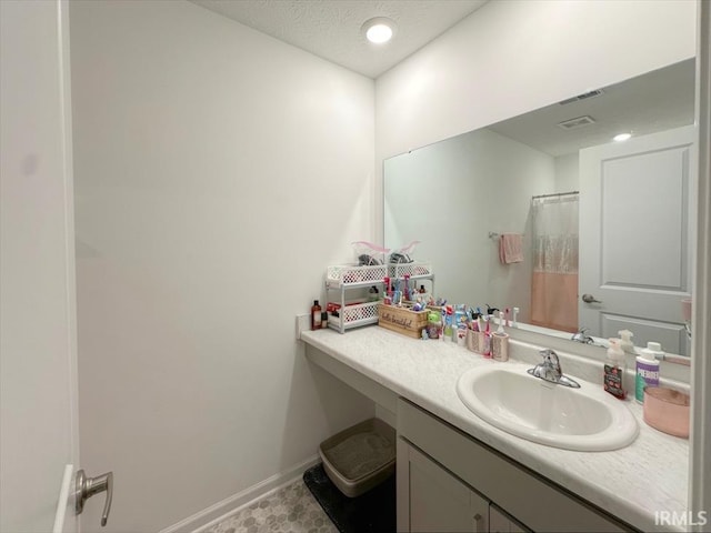 bathroom with vanity and a textured ceiling