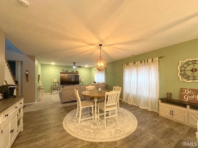 dining room with a notable chandelier, dark wood-type flooring, and a textured ceiling