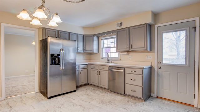 kitchen featuring sink, hanging light fixtures, appliances with stainless steel finishes, and gray cabinetry