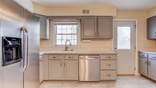 kitchen with sink, gray cabinetry, and appliances with stainless steel finishes