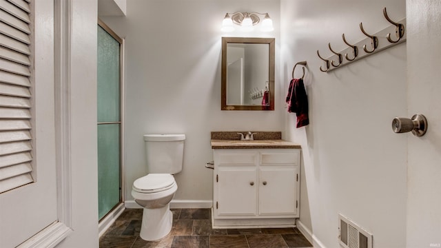 bathroom featuring toilet, vanity, and an enclosed shower