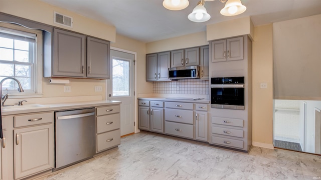 kitchen with sink, appliances with stainless steel finishes, gray cabinetry, and tasteful backsplash