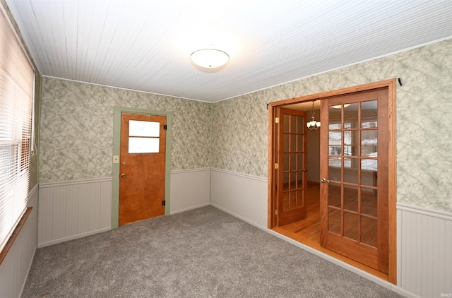 spare room with carpet and an inviting chandelier