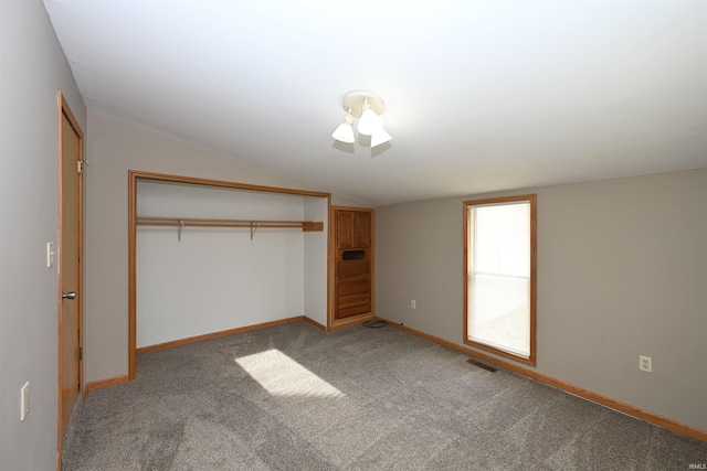 unfurnished bedroom with light colored carpet, a closet, and lofted ceiling