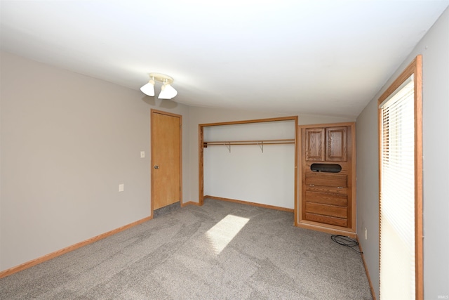 unfurnished bedroom with a closet, vaulted ceiling, and light carpet