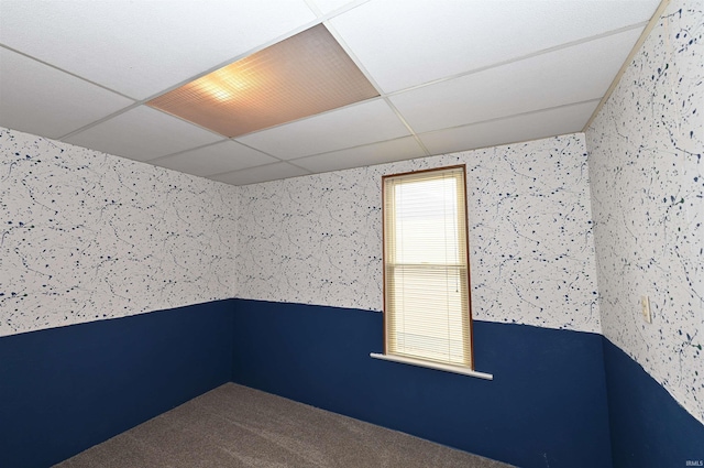 unfurnished room featuring a paneled ceiling and carpet floors