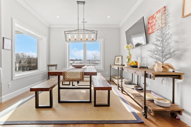 dining space featuring a chandelier, light hardwood / wood-style flooring, and ornamental molding