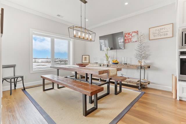 dining space featuring light hardwood / wood-style flooring and ornamental molding