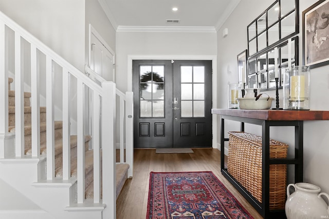 foyer entrance with french doors, crown molding, and hardwood / wood-style floors