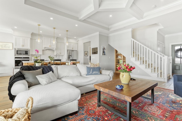 living room with crown molding, coffered ceiling, light wood-type flooring, and beam ceiling