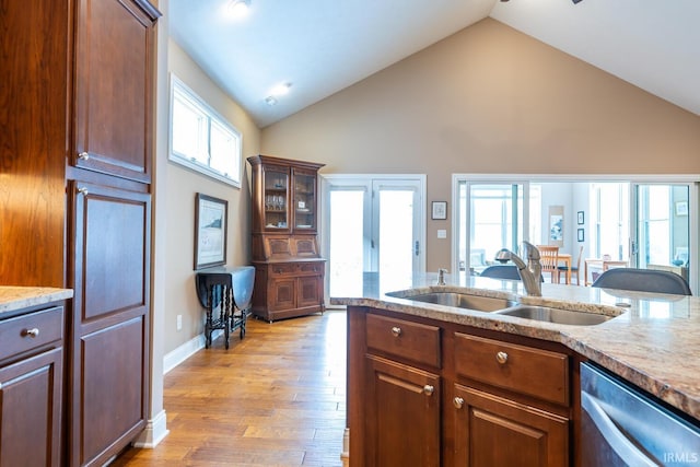 kitchen with sink, light wood-type flooring, plenty of natural light, and stainless steel dishwasher