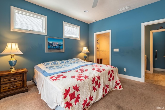 carpeted bedroom featuring a closet, ceiling fan, and a walk in closet