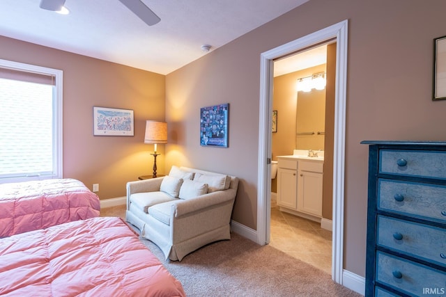 bedroom with light carpet, sink, ensuite bathroom, and ceiling fan