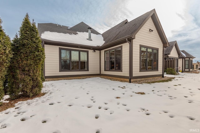 view of snow covered back of property