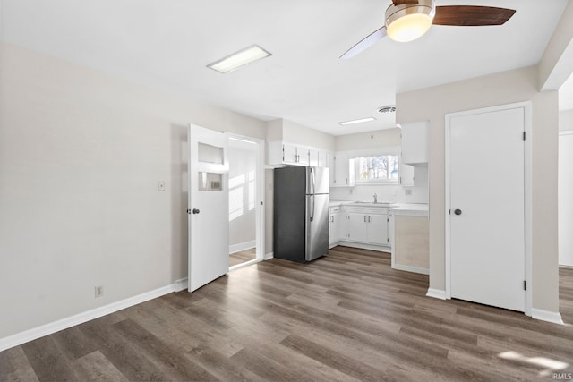 kitchen with white cabinetry, dark hardwood / wood-style floors, ceiling fan, and stainless steel refrigerator