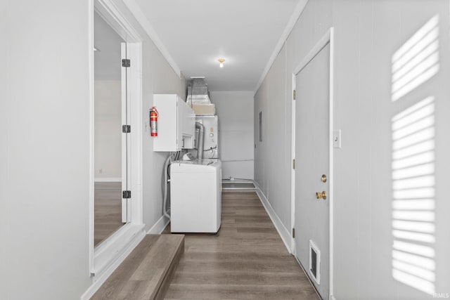 washroom featuring ornamental molding, hardwood / wood-style flooring, and washer / dryer